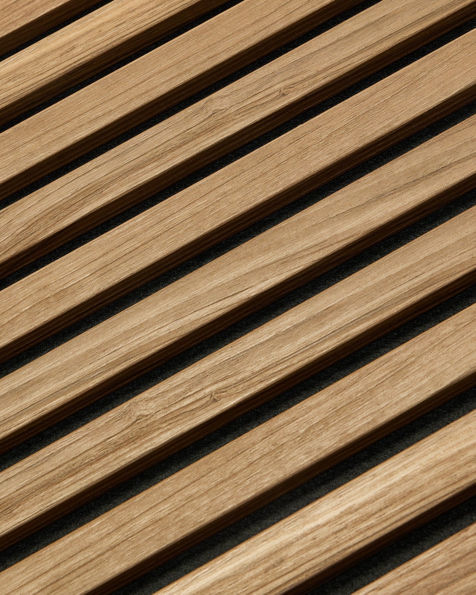 Diagonale Nahaufnahme von WoodUpp Akupanel Essential Akustikpaneel in English Walnut, 240x60 cm, mit gleichmäßiger Oberfläche und dunklem Hintergrund zwischen den einzelnen Holzlamellen.