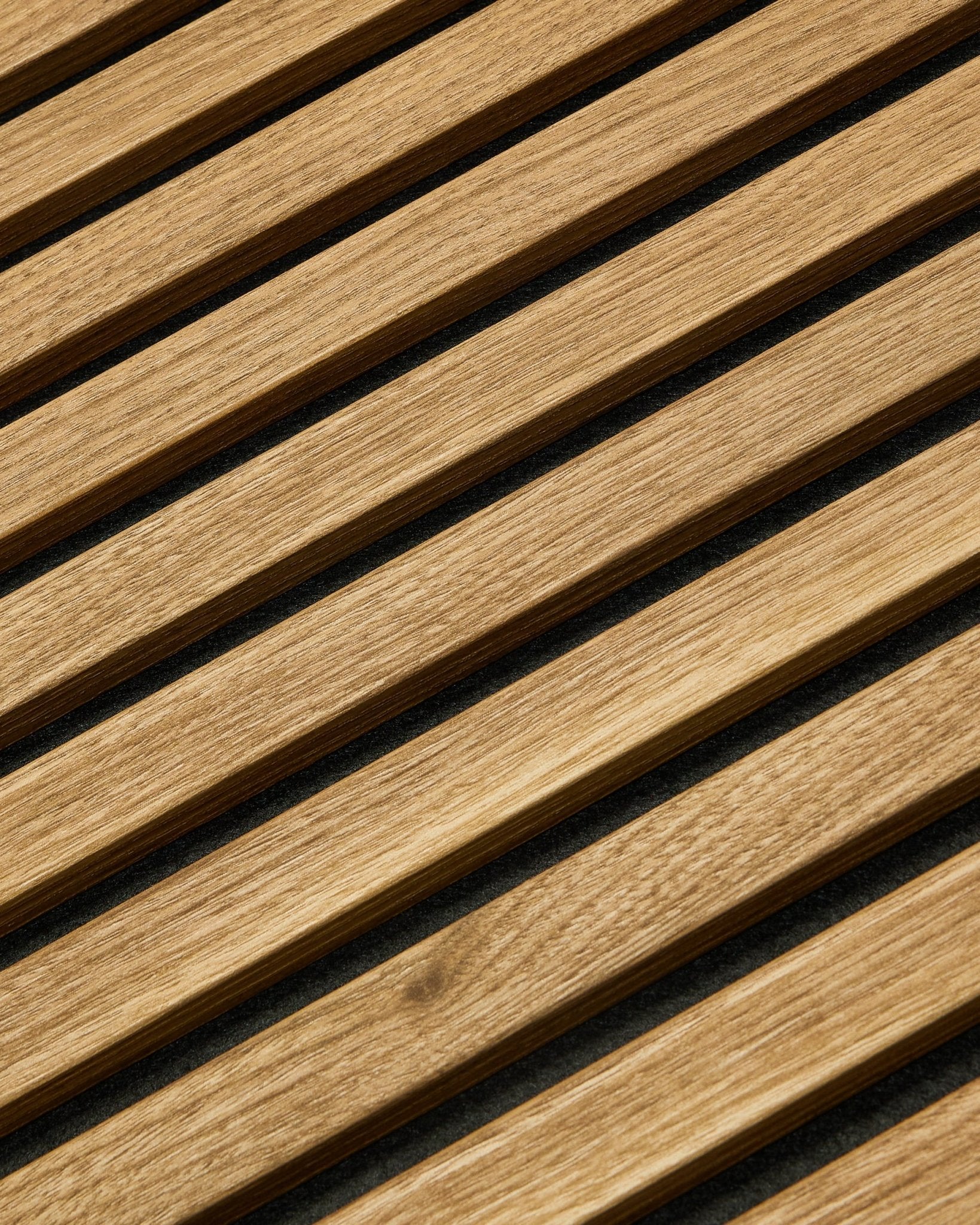 Essential Akupanel Akustikpaneel in Englischer Eiche von WoodUpp, 240 x 60 cm, mit gleichmäßig angeordneten diagonalen Lamellen auf dunklem Hintergrund.