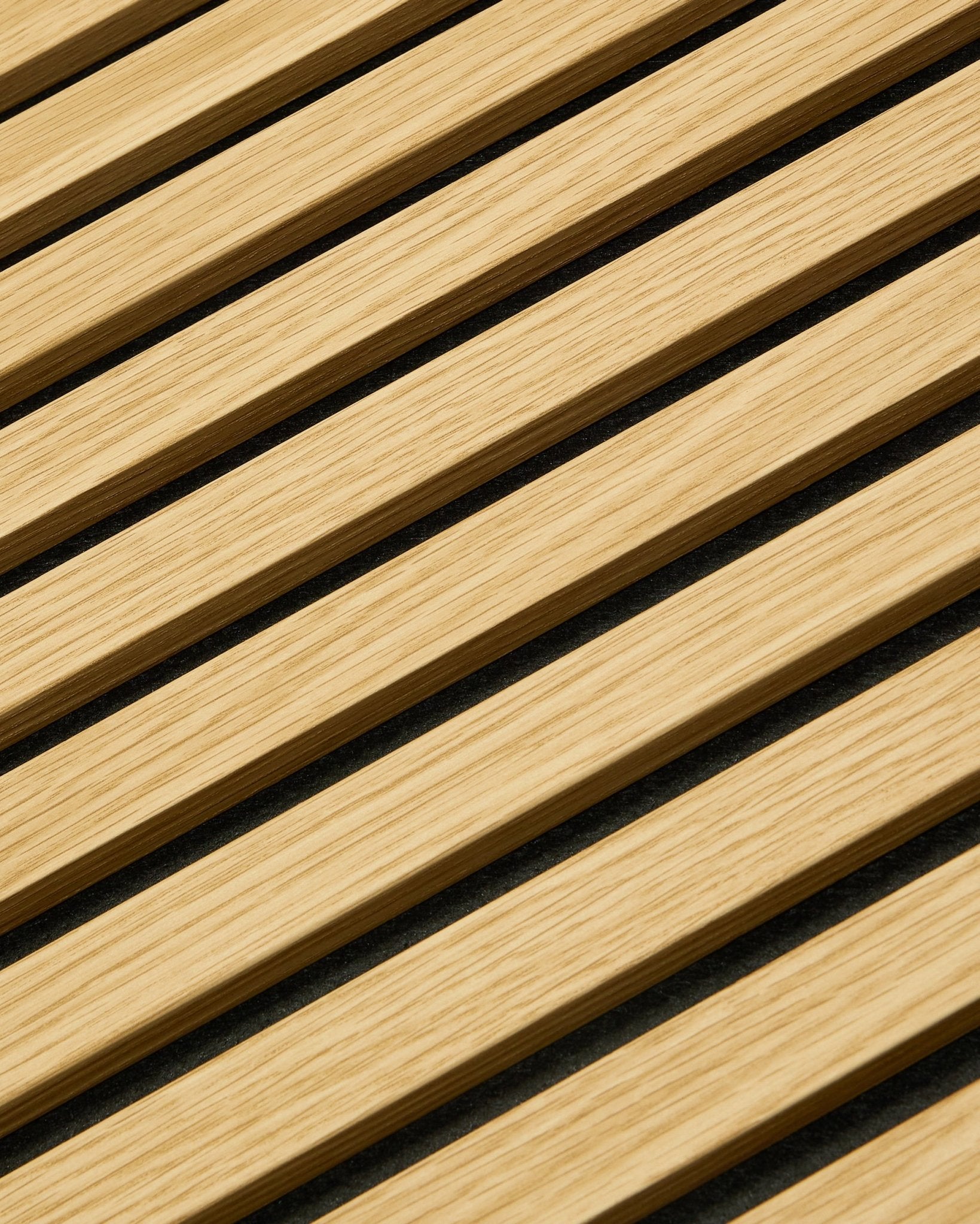 Nahaufnahme von WoodUpp Akupanel Akustikpaneel in Southern Oak, 240 x 60 cm, mit diagonalen Lamellen und dunklen Akustikfugen für eine verbesserte Schallabsorption.