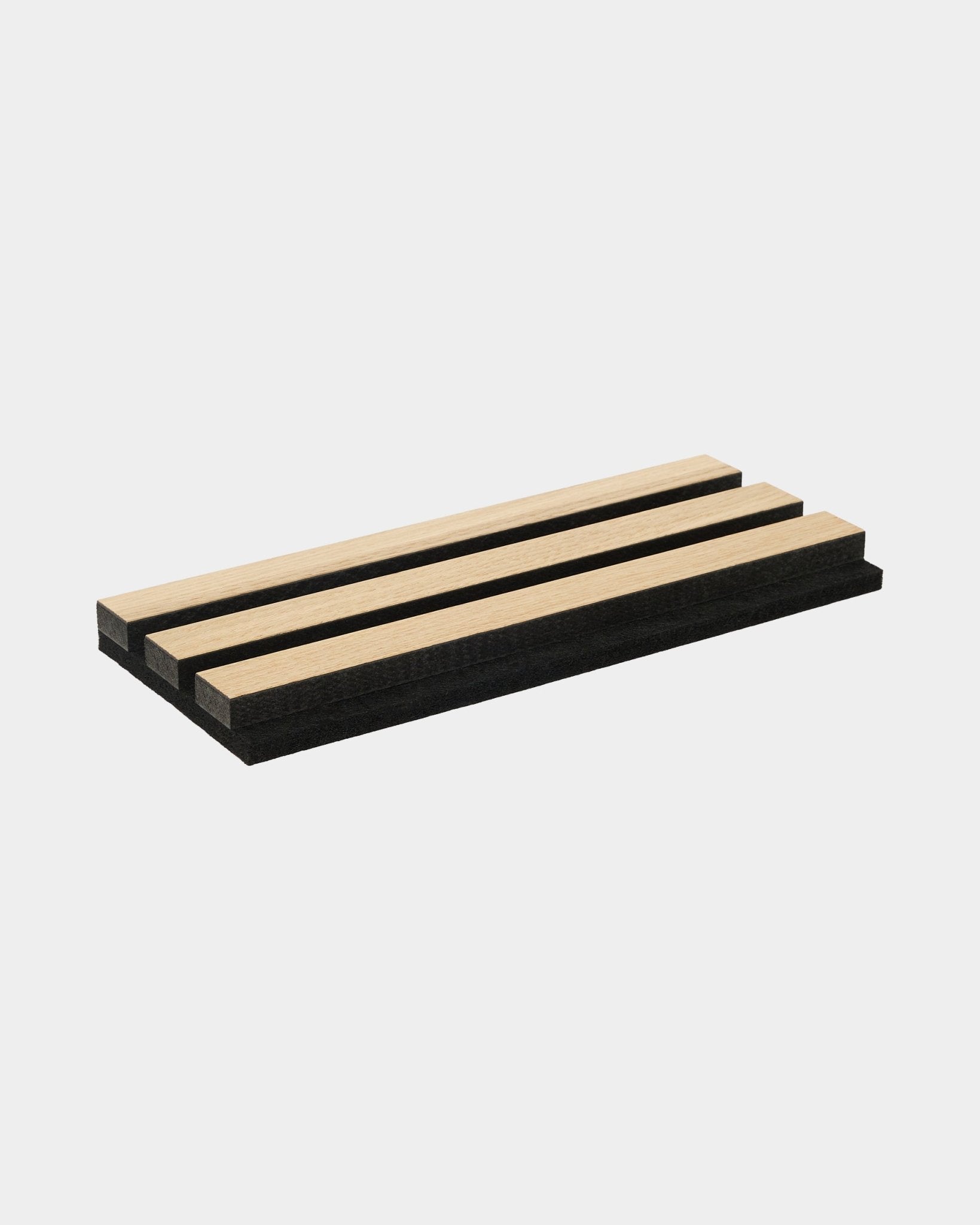 Akupanel Musterbox mit Akustiklamellen aus klassischer Eiche und black MDF mit black Filzrücken, arrangiert vor schlicht weißem Hintergrund.