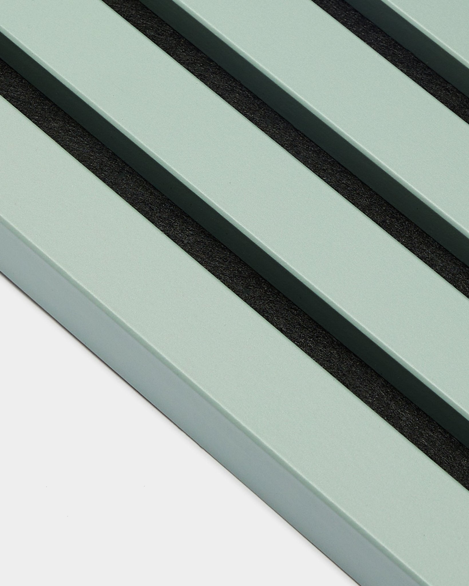 Nahaufnahme von drei parallelen pastellgrünen End Lamella / Cloud Lamellen, 2,2 cm breit, von WoodUpp, als Teil einer Akupanel Akustikpaneel vor hellem Hintergrund.