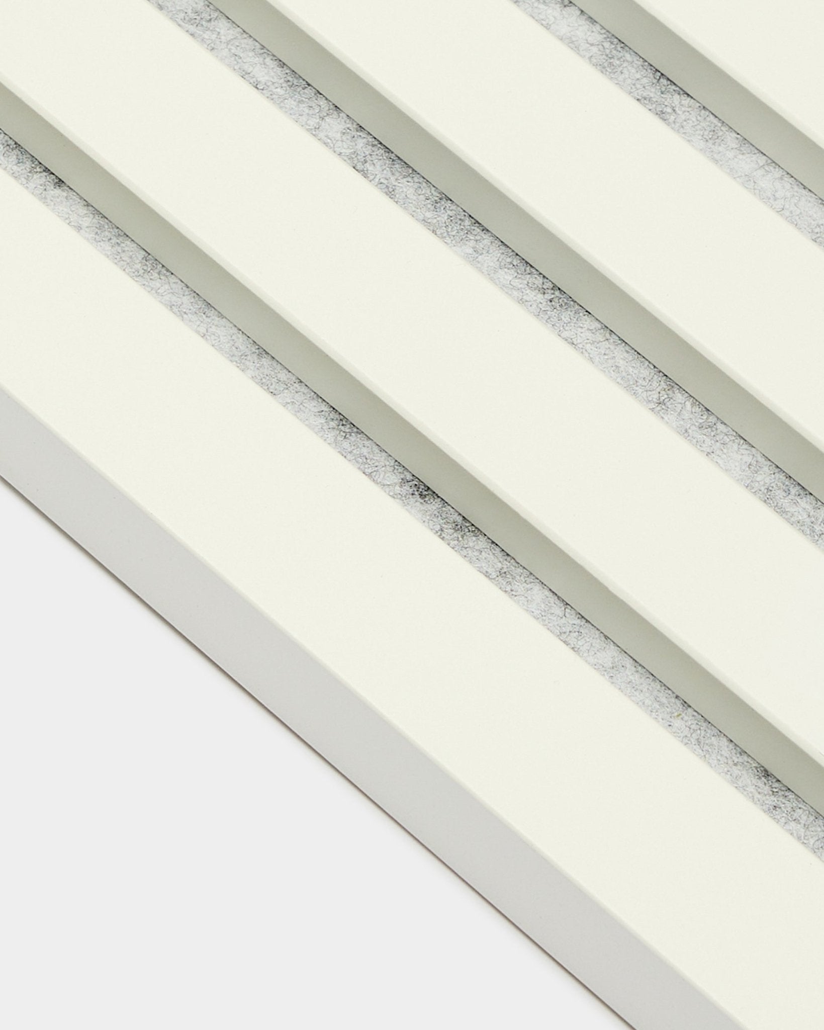 Vier WoodUpp Akupanel Endlamellen/Snow-Akustikpaneele (2,2 cm), diagonal angeordnet, mit cremeweißen Lamellen und strukturierten grauen Zwischenräumen im nordischen Stil.