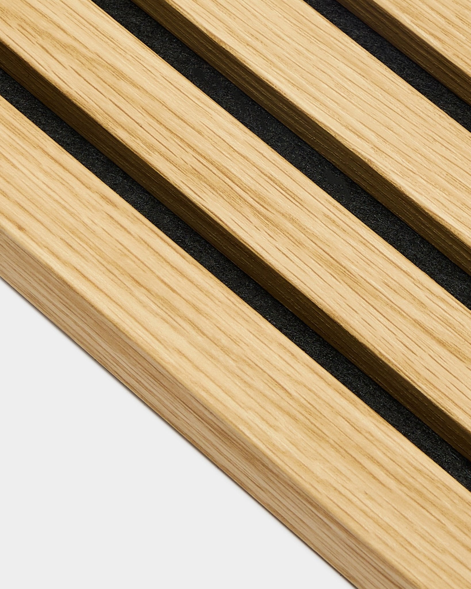 Nahaufnahme der WoodUpp Akupanel Endlamelle in Southern Oak, mit 2,2 cm breiten Lamellen und black Fugen, diagonal auf einem hellen grey Hintergrund angeordnet.