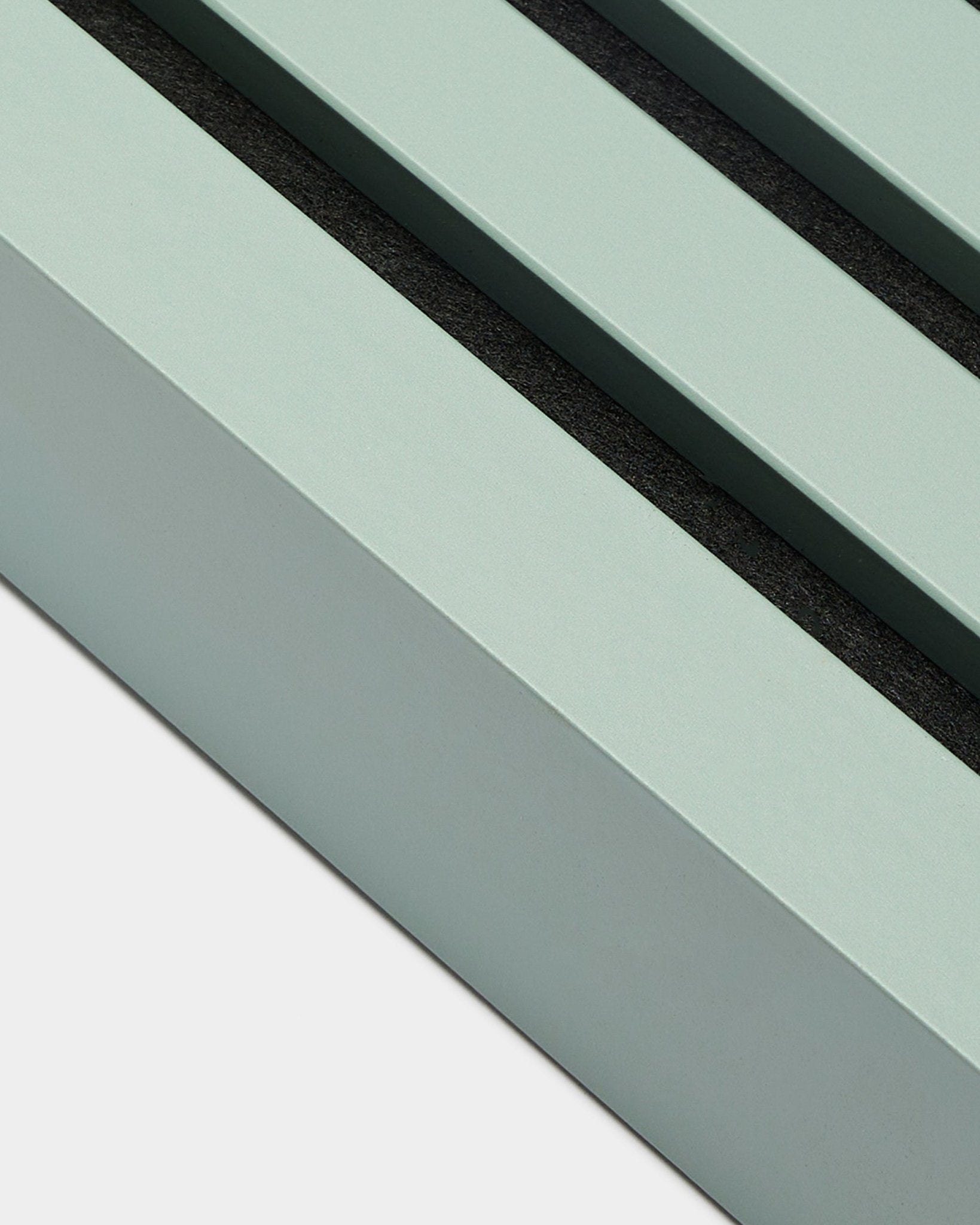 Nahaufnahme des WoodUpp-Installationszubehörs Akupanel: End-Lamelle in Cloud, 6,7 cm breit, mintgrüner MDF-Rahmen mit zwei black-Nuten vor weißem Hintergrund.