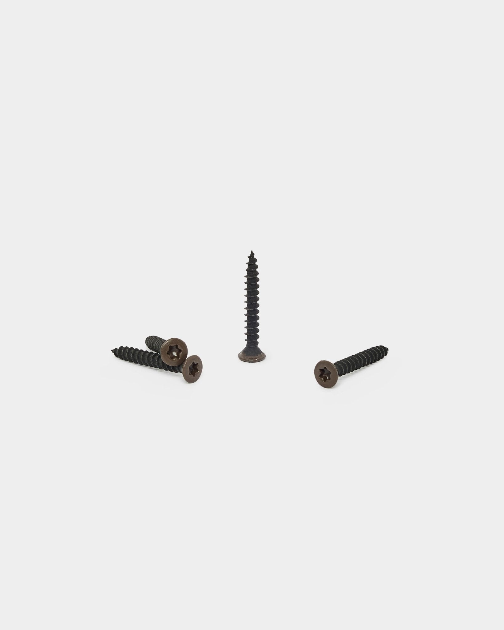 Drei bronzed brown WoodUpp Schrauben, eine aufrecht und zwei liegend, zum Befestigen der Filzrückseite an Akupanel Akustikpaneelen. Packung mit 100 Stück.