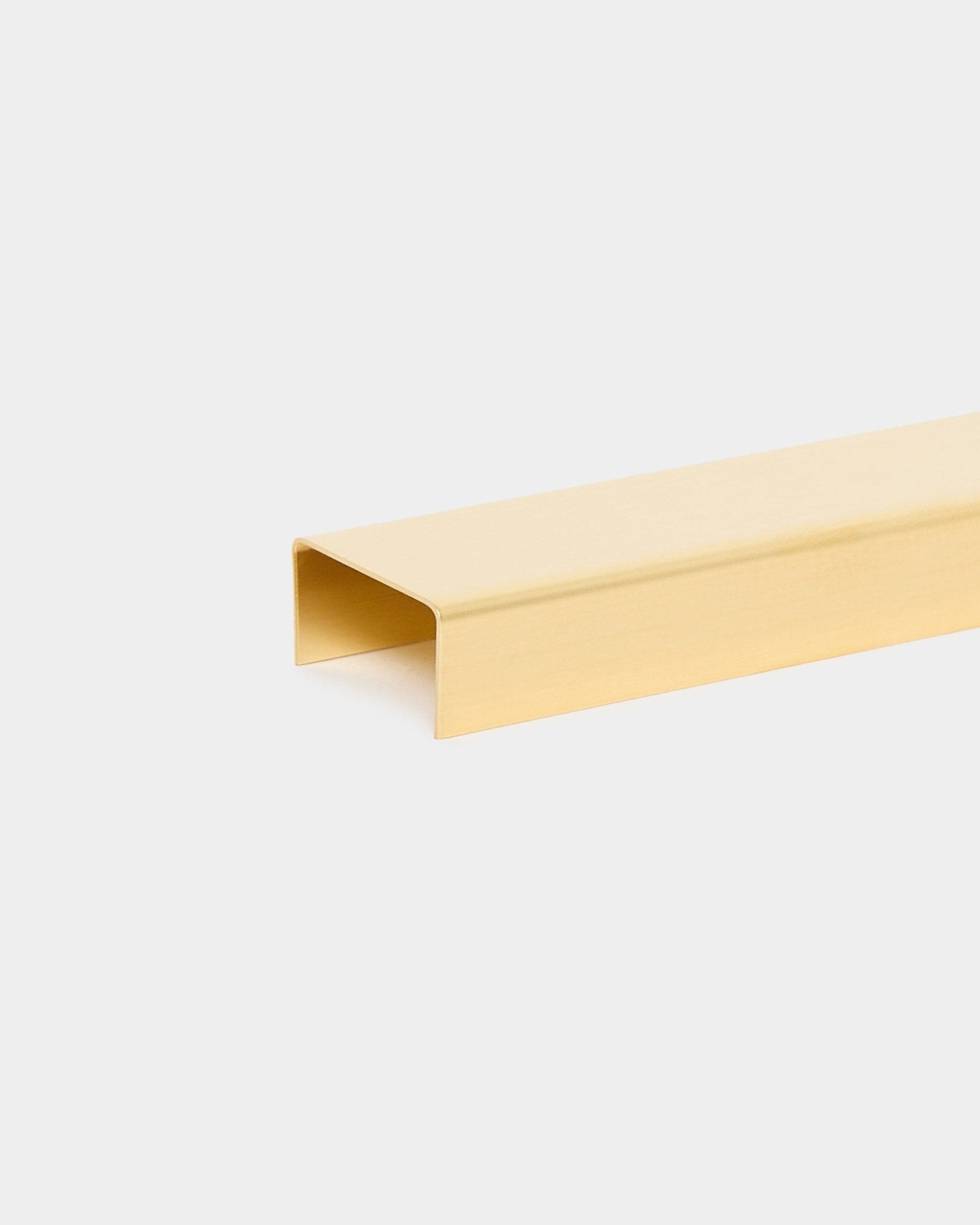 Die Liva Cover in brass, 20 cm, von WoodUpp ist ein goldener U-förmiger Metallkanal, der als Abschlussabdeckung für Akupanel Akustik-Holzpaneele konzipiert ist.