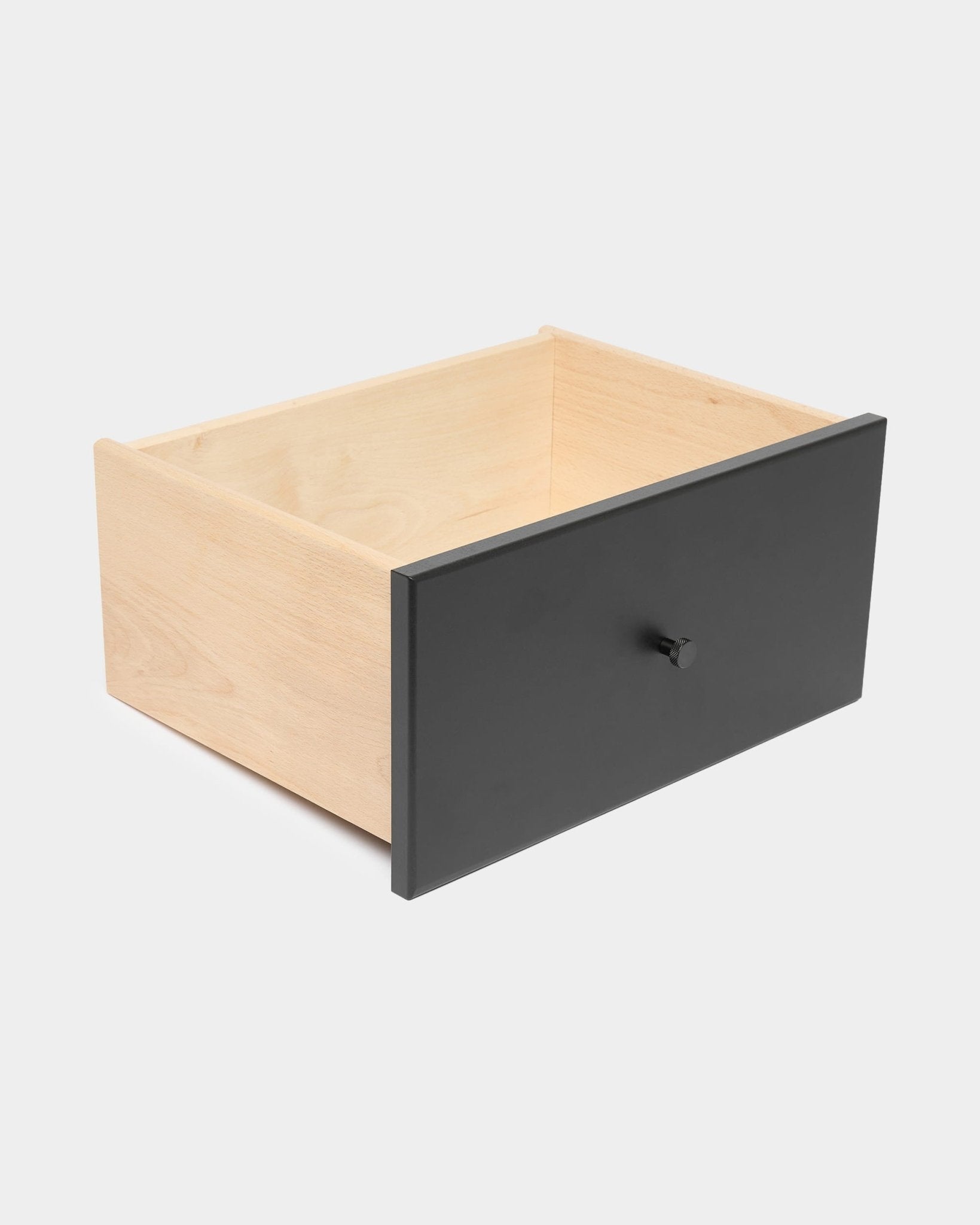 WoodUpp Arka – schwarzes Bücherregal mit Schublade und rundem Knauf, das geschlossenen Stauraum bietet, vor einem schlichten weißen Hintergrund.