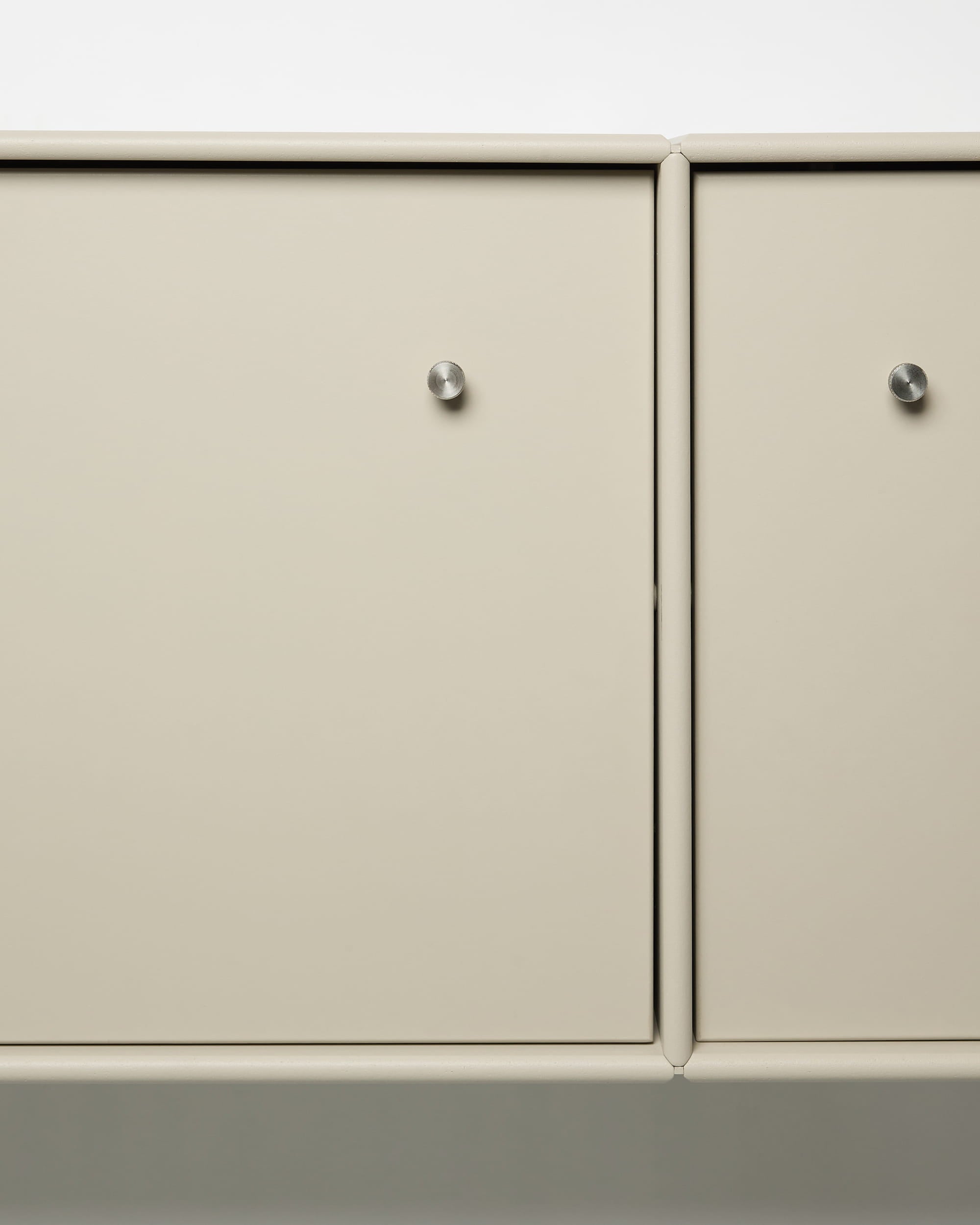 Arka TV-Konsole von WoodUpp mit beigen Metalltüren, runden silbernen Knöpfen, modularem Aufbau und integrierter Kabelführung – ideal für nordische Einrichtungsstile.