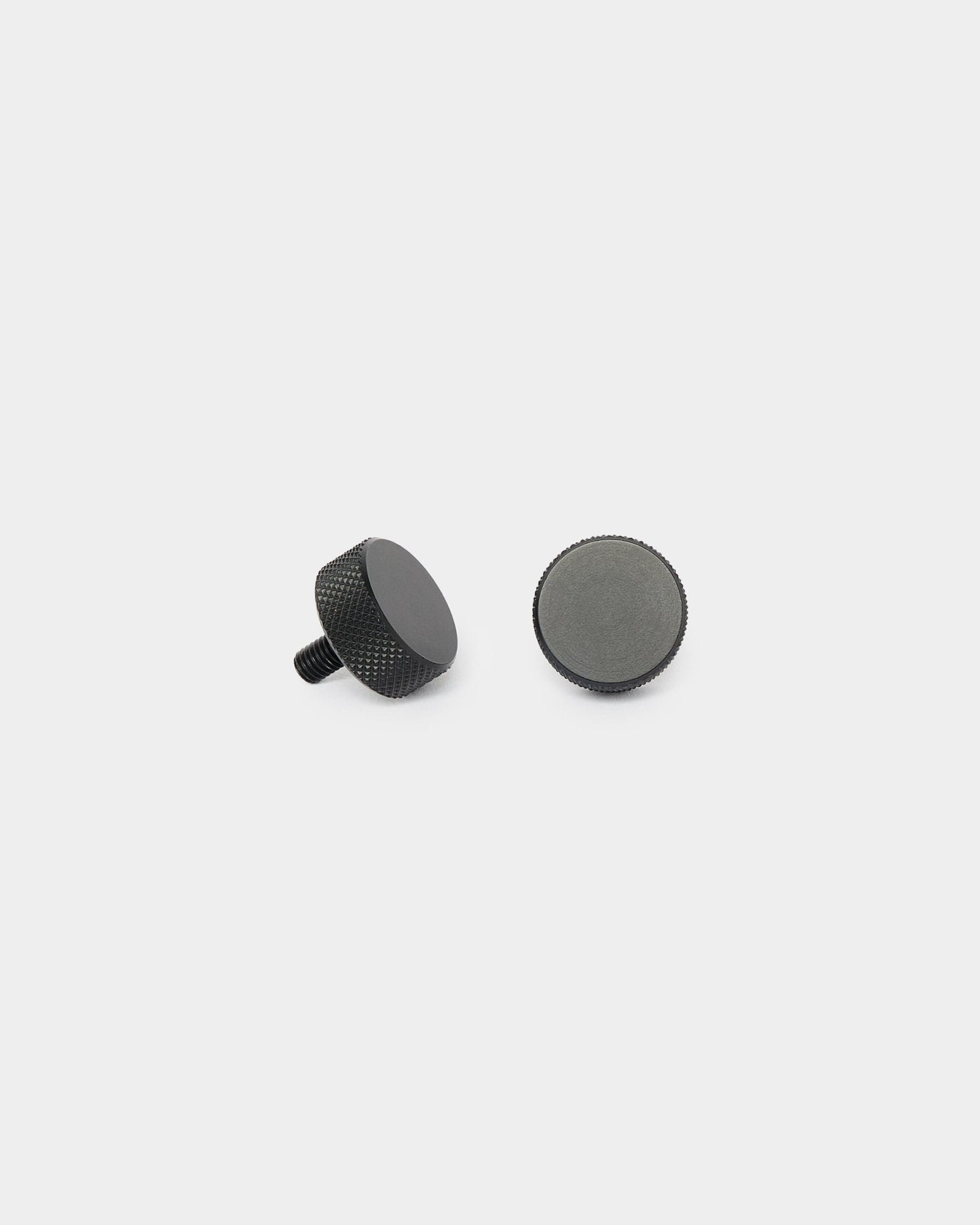Zwei black WoodUpp Finger-Schrauben (2 Stk., M5x10 mm, 20x8,8), aufrecht stehend und seitlich liegend, auf schlichtem weißem Hintergrund für die Montage von Akupanel.