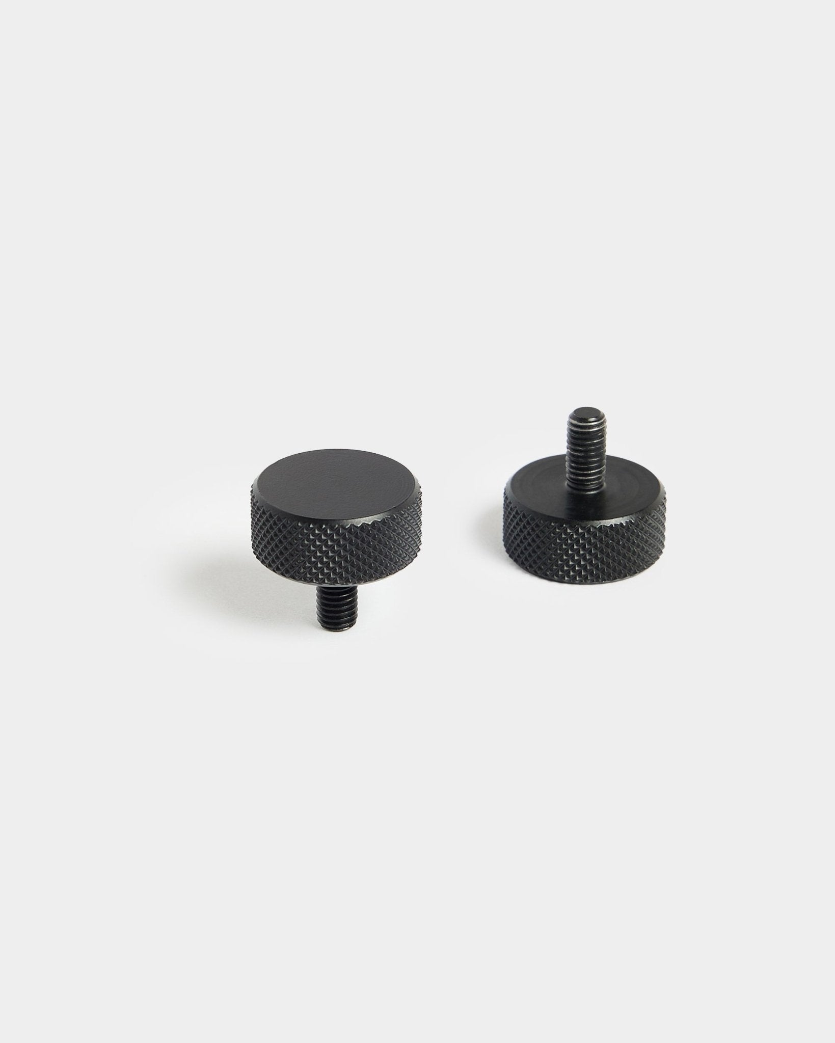 Paar black WoodUpp Finger-Schrauben (M5x10 mm, 20x8,8) mit gerändelten Kanten, konzipiert für die Verwendung mit Akustikpaneel Zubehör, auf schlichtem weißem Hintergrund.