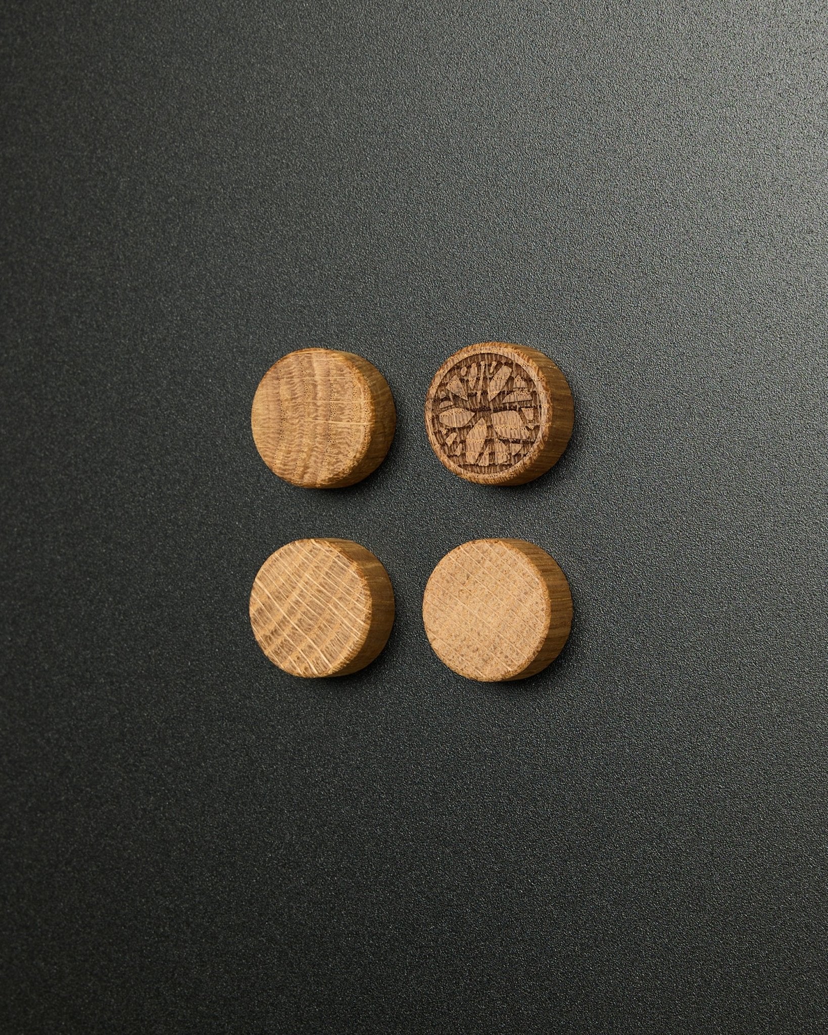 Set mit vier massiven natural oak Magneten von WoodUpp, davon einer mit eingeschnitztem Zitrusscheiben-Design, entwickelt für die Verwendung mit dem Norr Magnetic Board Akustikpaneel.