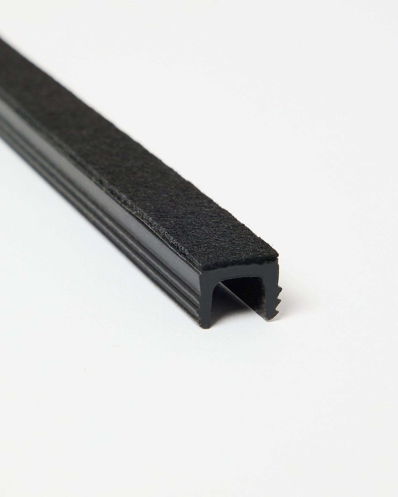Drei black Dupps Pop-on Kabelabdeckungen von WoodUpp, auf weißem Hintergrund schräg dargestellt, um Form und Oberfläche zu zeigen. Zubehör für Akupanel Systeme.