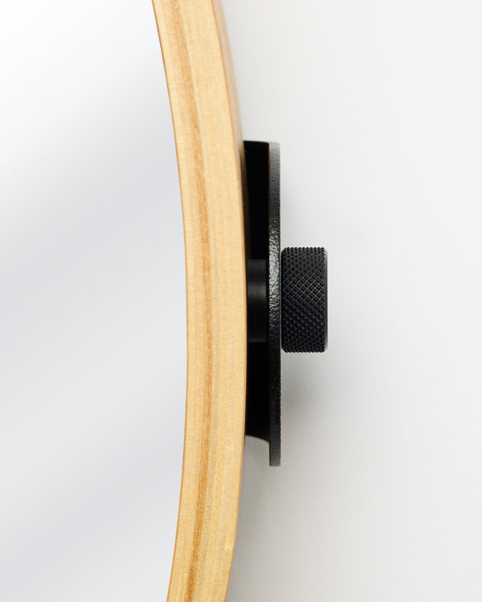 Seitliche Nahaufnahme des WoodUpp Linn | Mirror in Natural Oak mit rundem Eichenrahmen und Metallknauf in black, ein Accessoire für akustische Holzpaneele.
