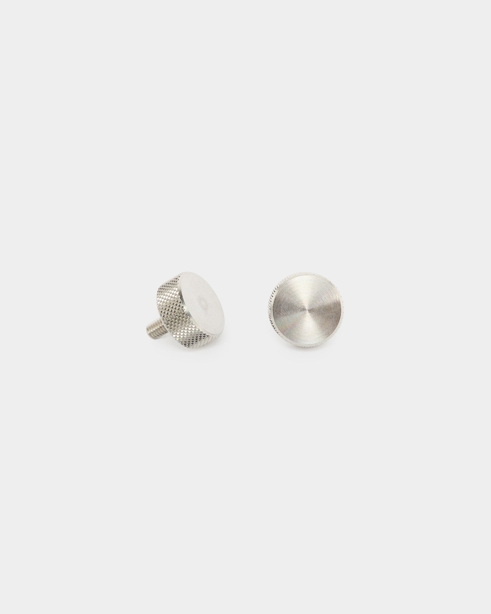 Zwei WoodUpp Fingerschrauben aus Edelstahl steel (M5x10 mm, 20x8.8), Zubehör für Akupanel Akustikpaneele, auf schlicht weißem Hintergrund stehend und liegend dargestellt.