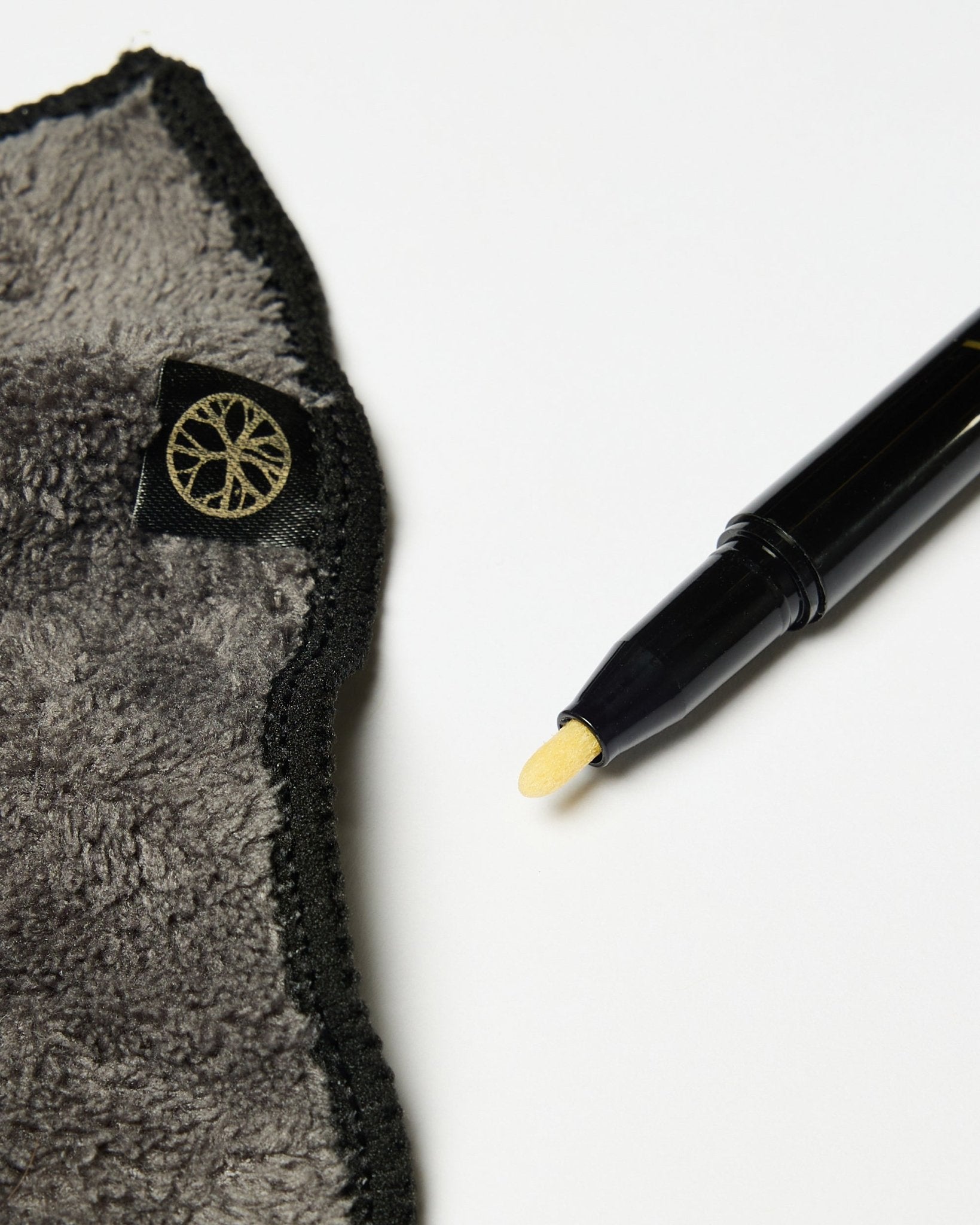Das Norr Blackboard-Set von WoodUpp enthält einen black Kreidemarker mit gelber Spitze und ein graues Mikrofasertuch mit goldenem Etikett, präsentiert auf einer weißen Oberfläche.