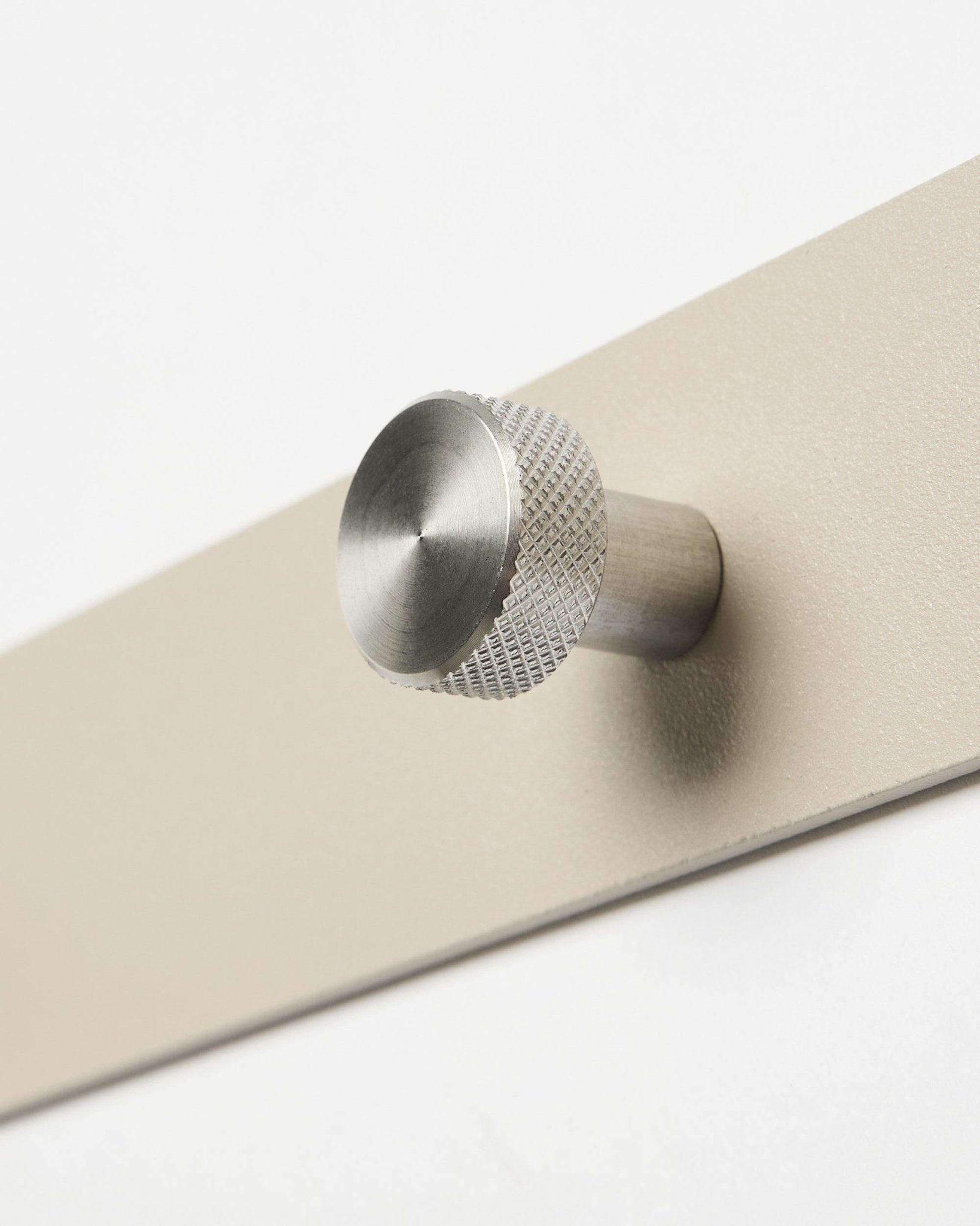 Norr Garderobenhakenleiste in beige und Edelstahl steel von WoodUpp, Zubehör für die Akupanel Kollektion, als Nahaufnahme vor weißem Hintergrund gezeigt.
