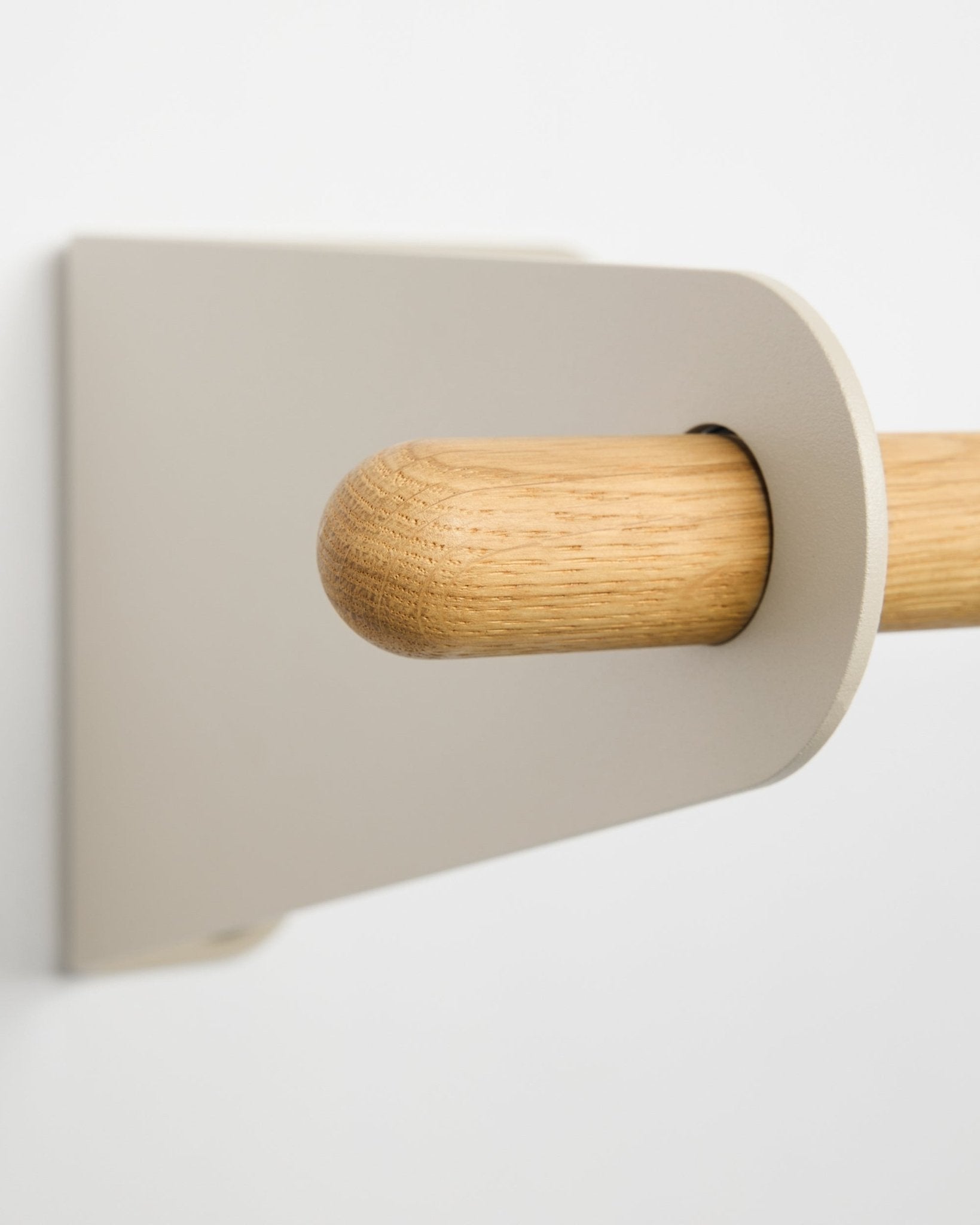 Nahaufnahme der WoodUpp Linn Garderobenstange in beige, 115,9 cm, mit einer hellen beige Metallhalterung, montiert an einer weißen Wand. Nordisches minimalistisches Designaccessoire.