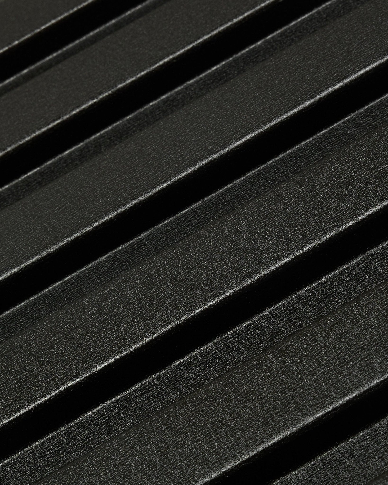 Nahaufnahme des Aluwood Fassadenpaneels für den Außenbereich von WoodUpp: dunkle, strukturierte Oberfläche aus recyceltem Aluminium mit diagonalen erhabenen Rillen, 240 x 45,1 cm.