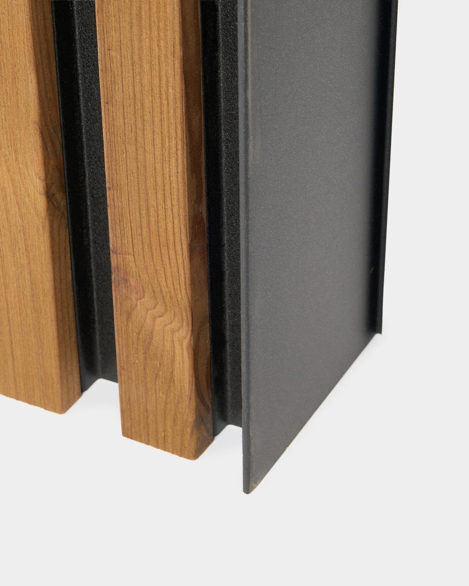Nahaufnahme des WoodUpp Aluwood Fassadenpaneels, 240 cm, mit verticalen Holzlamellen und einem dunkel pulverbeschichteten Aluminiumprofil für die Montage im Außenbereich.