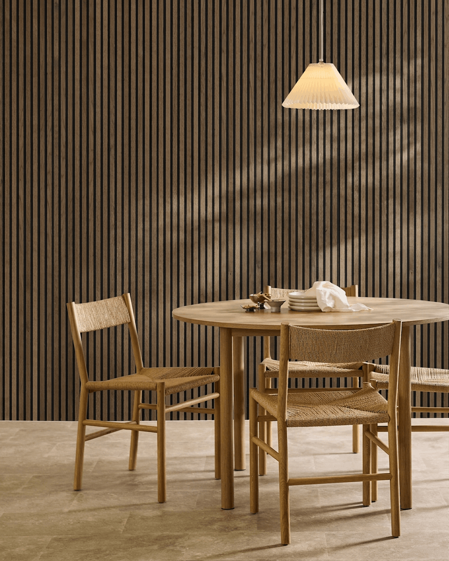 Minimalistischer Essbereich mit rundem Tisch, geflochtenen Stühlen und Pendelleuchte, mit einem WoodUpp Akupanel Rustic Grey Oak Akustik-Lamellenwandpaneel.