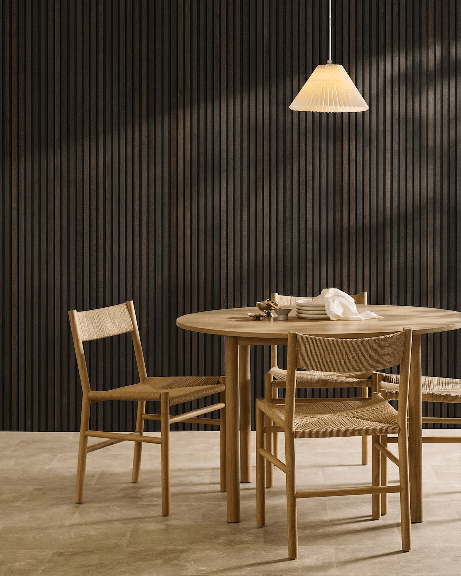 Minimalistischer Essbereich mit einem Holztisch, skandinavischen Stühlen, Pendelleuchte und einem WoodUpp Akupanel Rustic Smoked Oak Akustik-Lamellenwandpaneel.