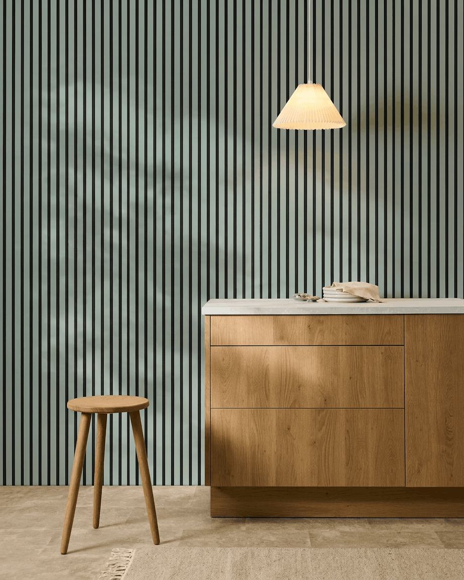 Minimalistische nordische Küche mit einem Holzstuhl, einem Schrank und WoodUpp Akupanel Akustikpaneel in der Farbe Cloud mit black Filz (240x60cm) für akustischen Komfort.