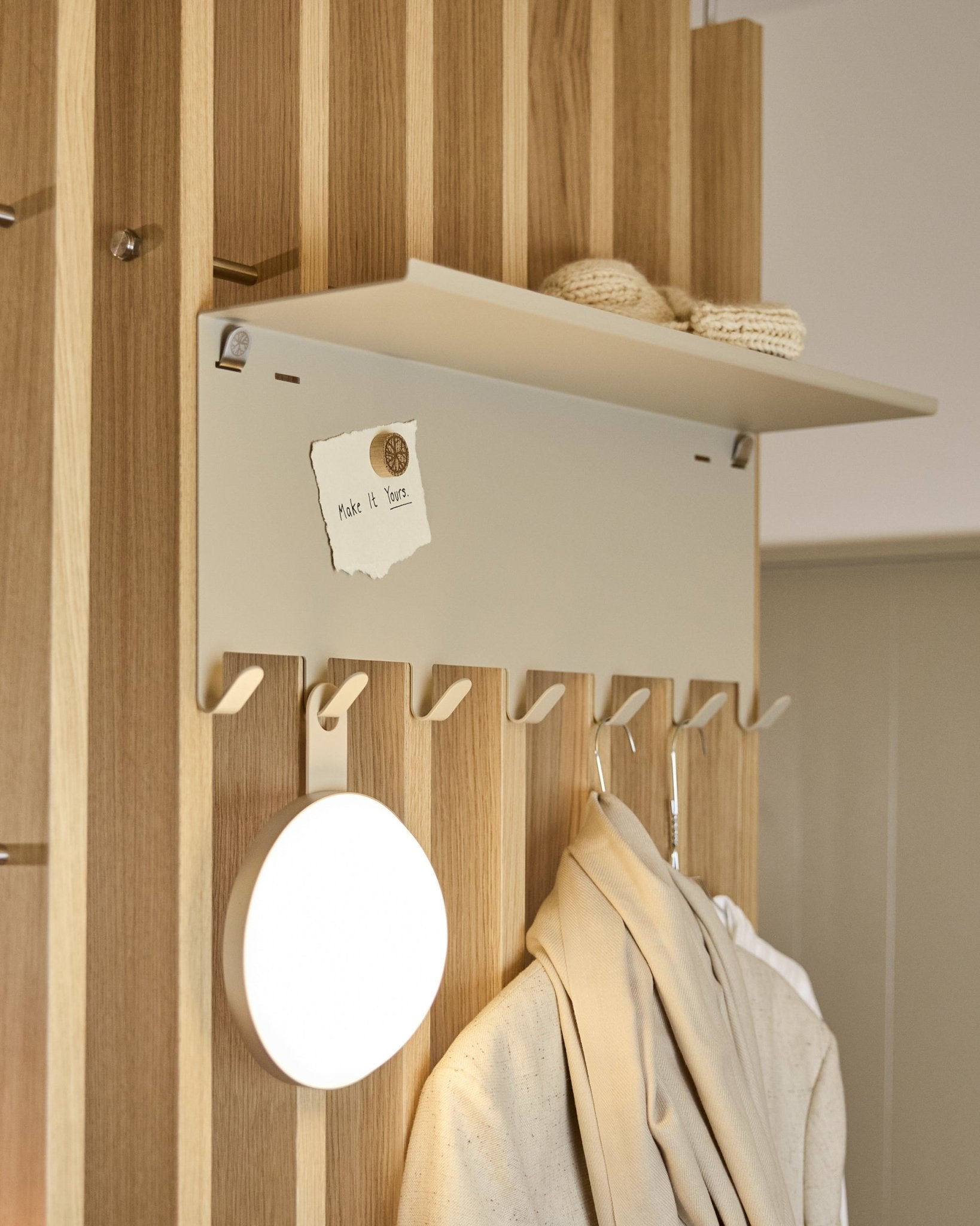WoodUpp Nell | BM1 Garderobenleiste in beige (63,5 x 24 cm), mit steel Haken und einer Ablage mit Strickwaren und einer Notiz mit der Aufschrift embrace BM1.