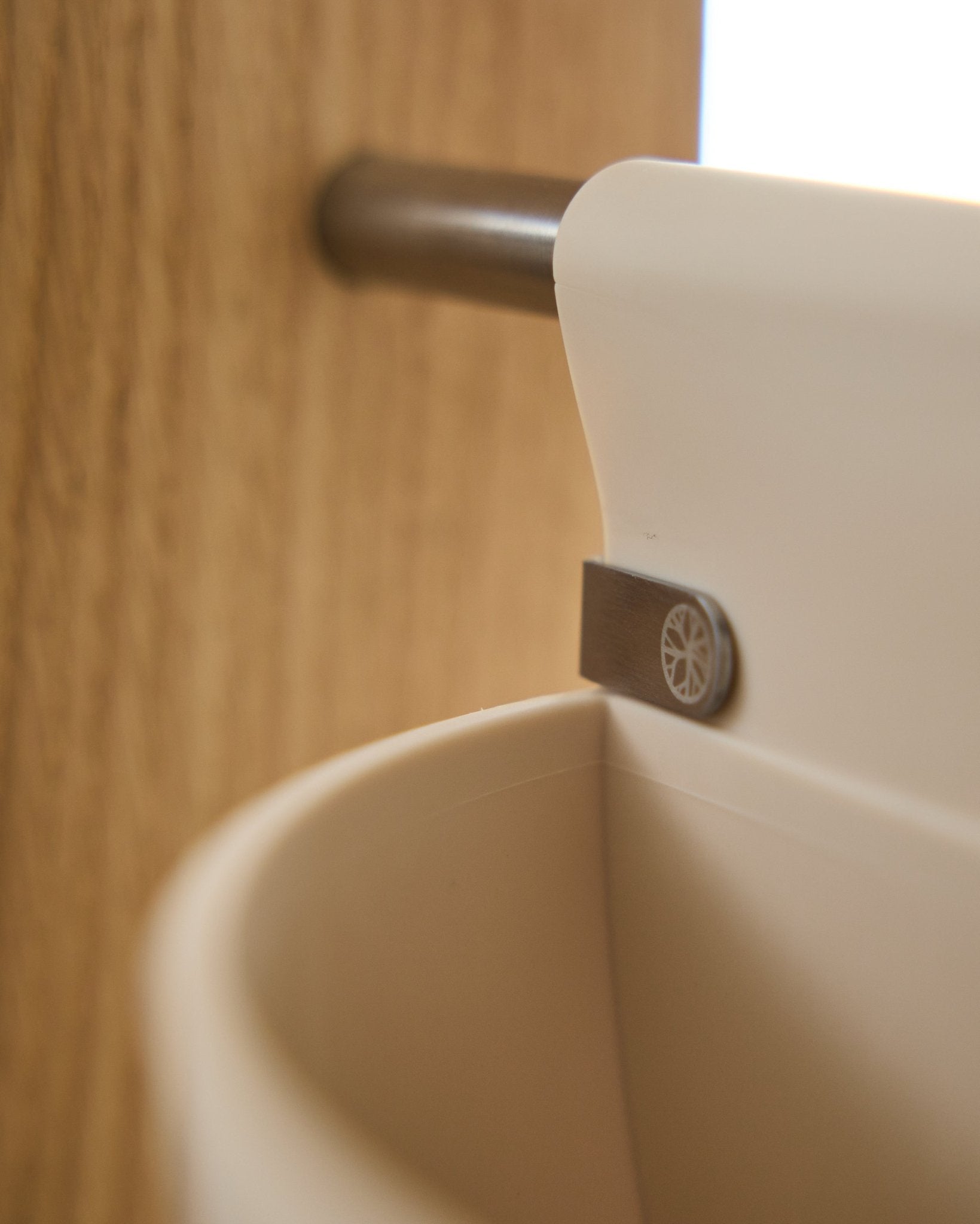 Nahaufnahme von Gro | Soft Pocket / BM2 (4 l) in hellem beige von WoodUpp, hängend an einer an Holz montierten Metallstange; unscharfer Hintergrund. Nordisches Akustik-Accessoire.