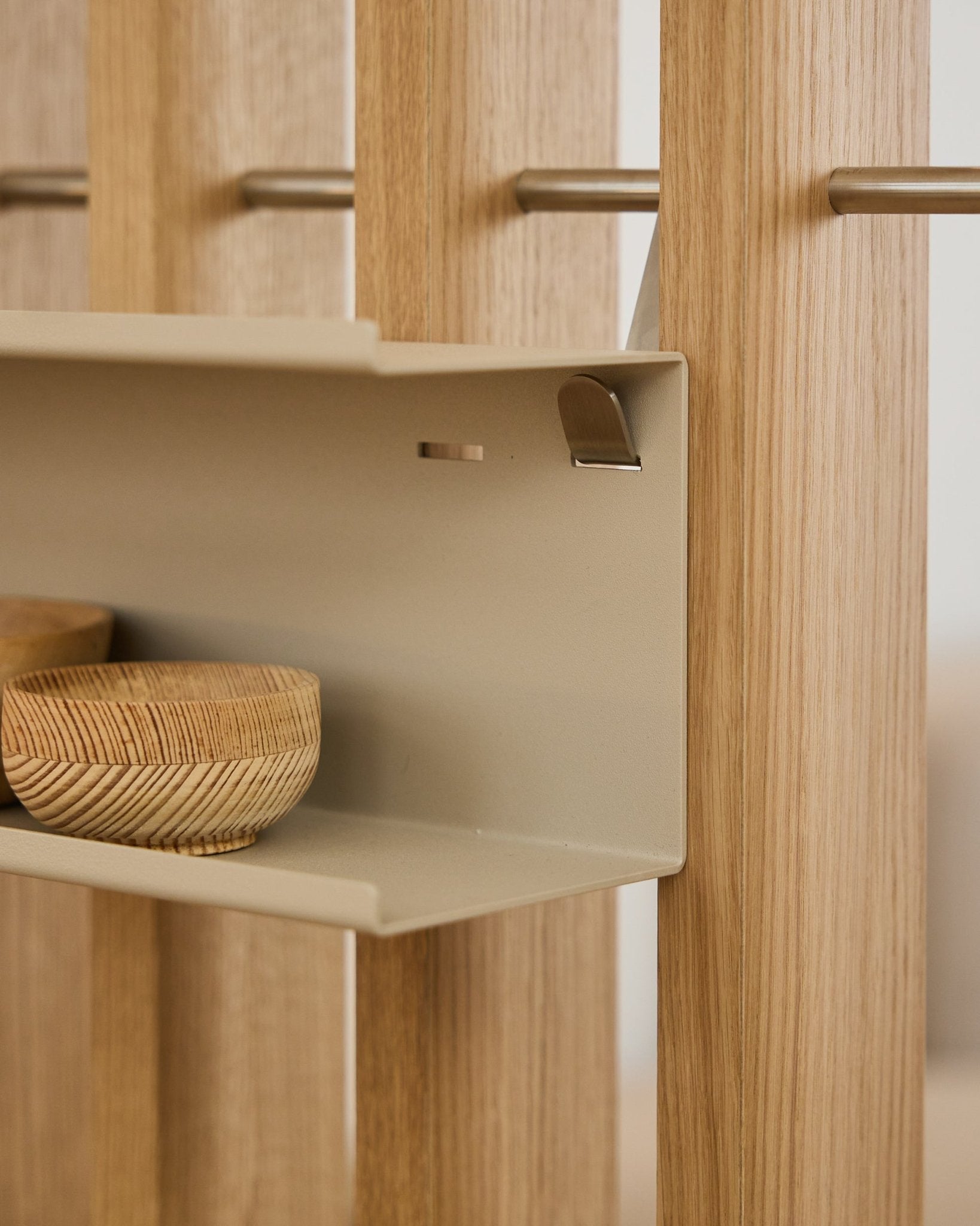 Nahaufnahme des WoodUpp Nell Double Metal Shelf / BM1 in beige, 63,5 cm, mit geflochtenen Schalen und vertical nordischen Akustik-Holzlamellen auf steel Stäben.